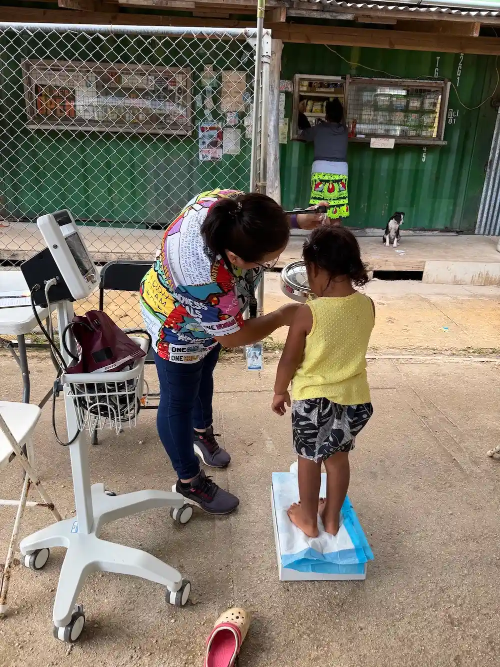 Healthcare worker measuring a child's height during a community health screening in Yigo, Guam